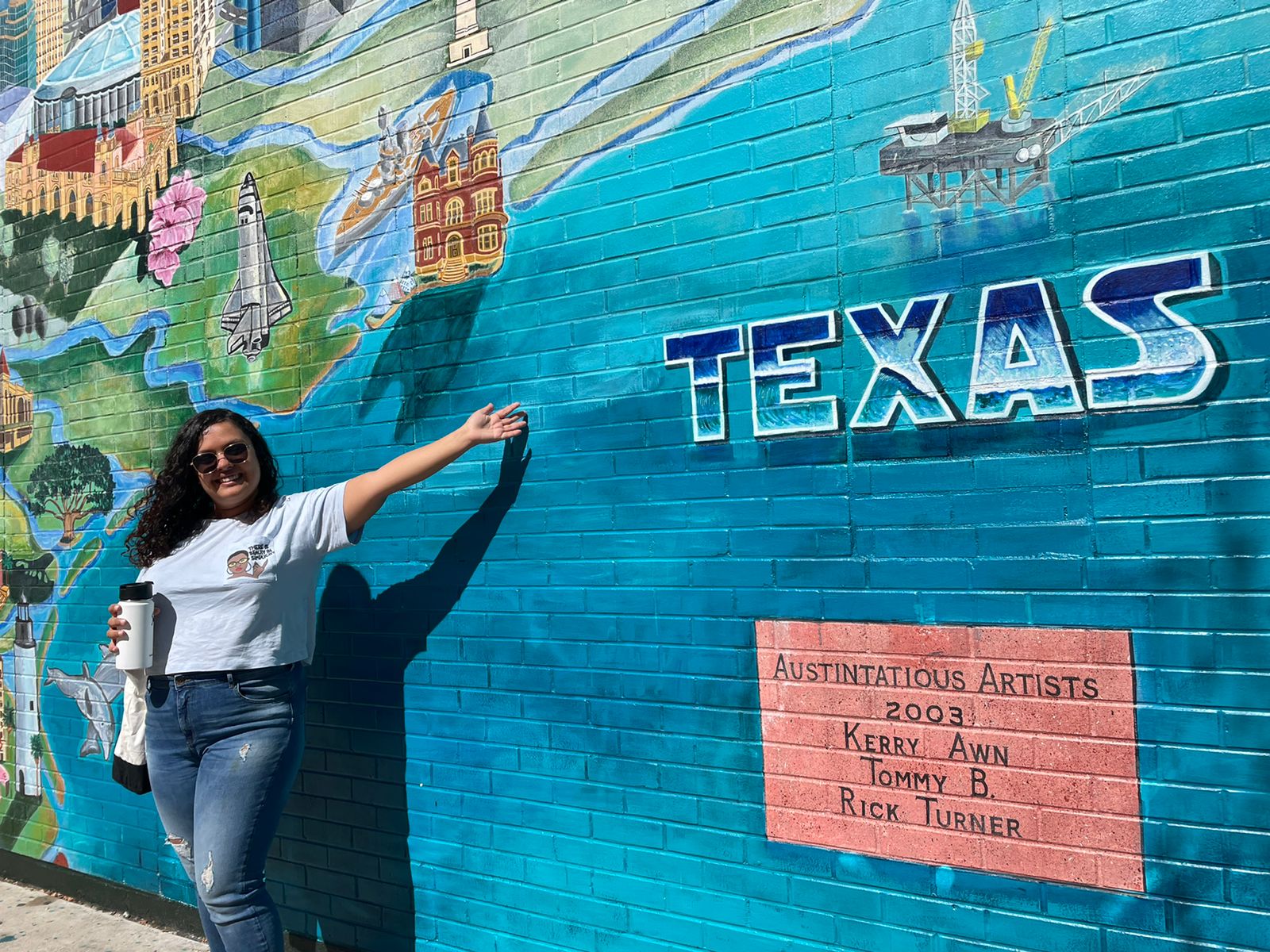 Fellow in front of Texas mural