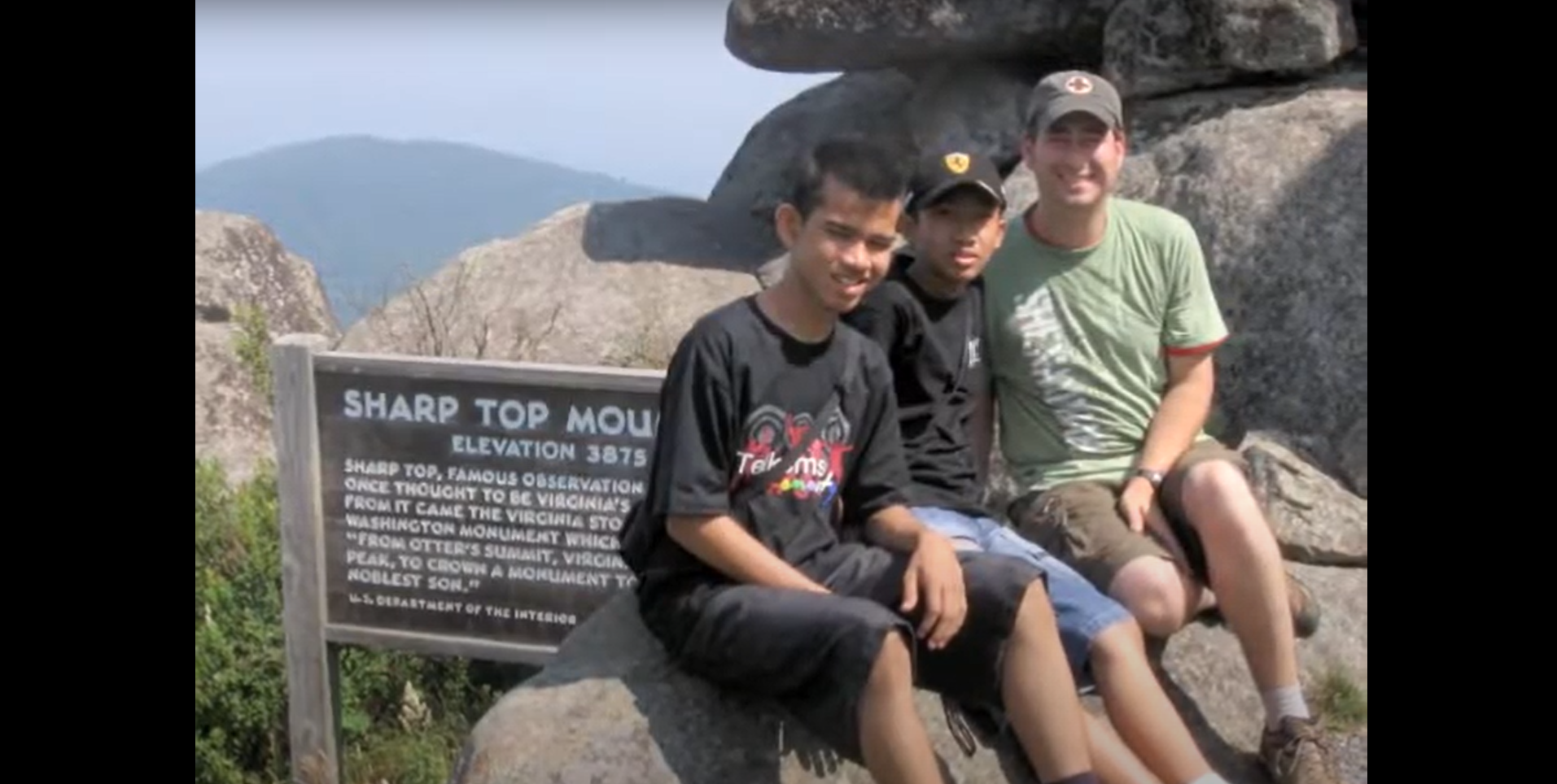 Three guys sitting on a rock